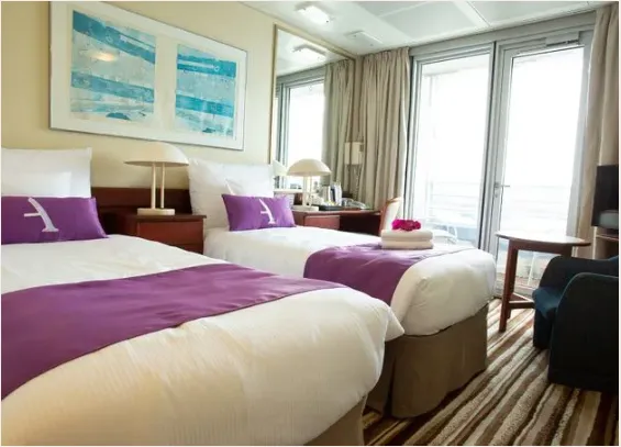 A Balcony twin cabin aboard the Ambassador, with doors onto a private balcony