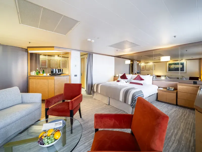 An Ambassador suite with a separate lounge, armchairs and a double bed
