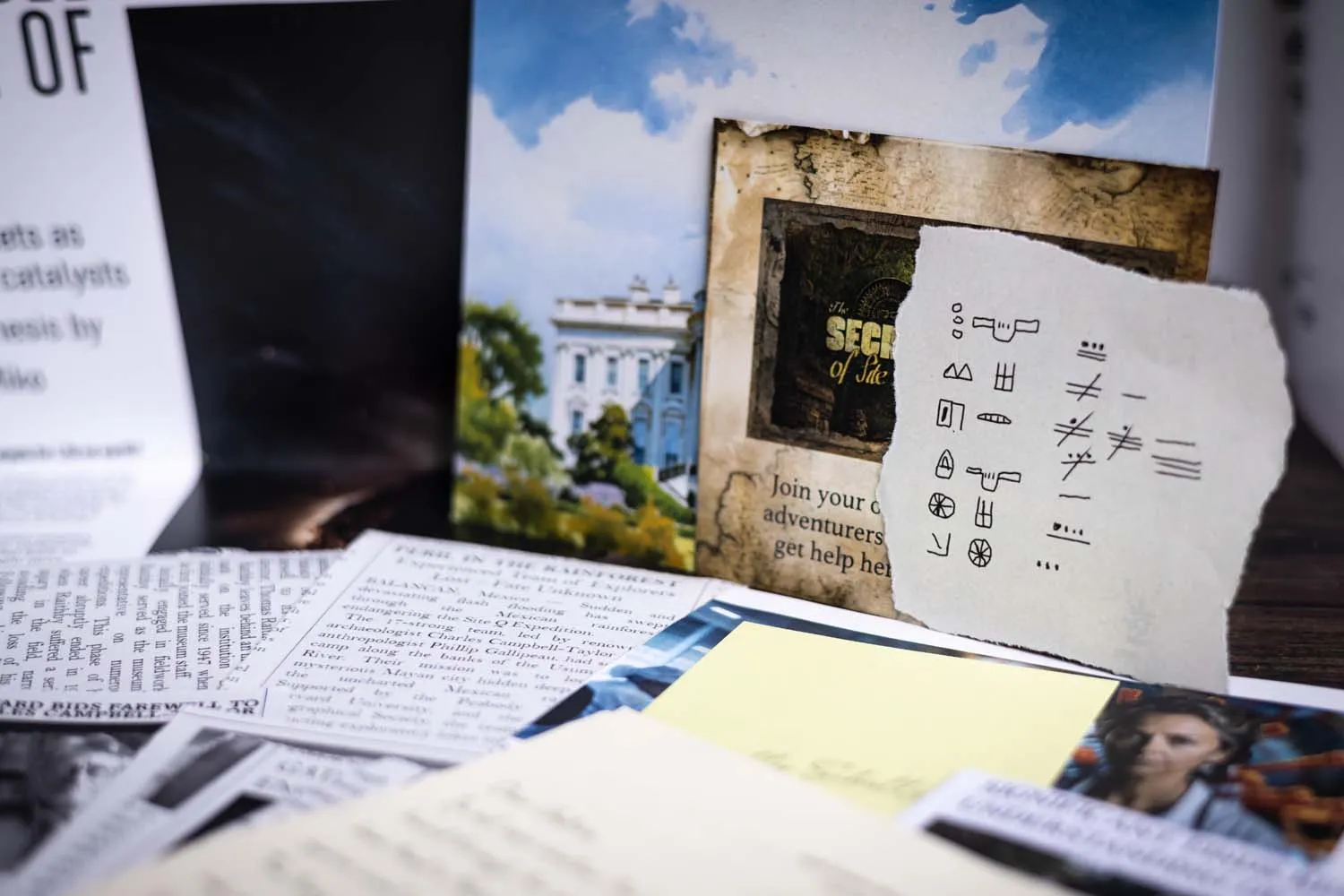 A cipher wheel, fold-marked map and cryptic telegram laid out on a dark wooden desk