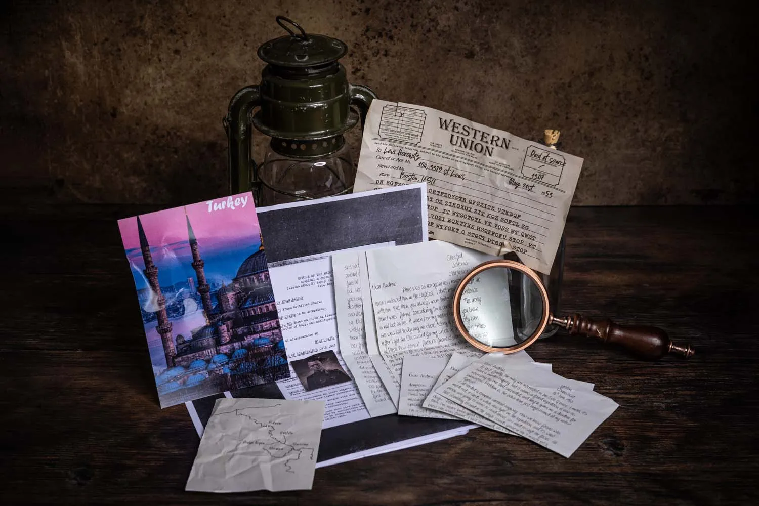 Detail of personal effects and a pressed botanical from a Cosykiller case, still arranged on the dark desk