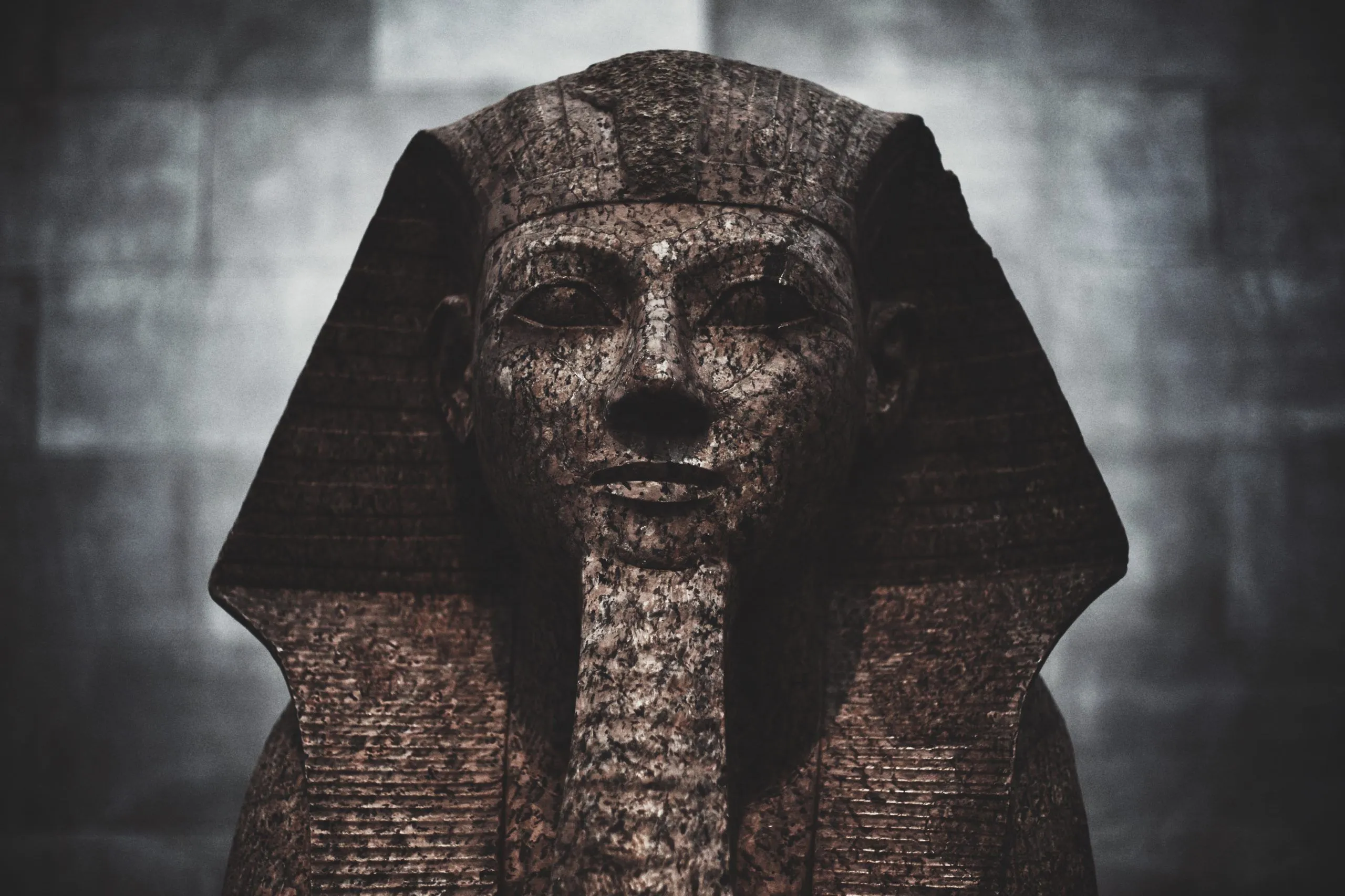 A granite pharaoh statue lit from below against a dim museum wall — the opening of The Curse of Humanrah case file